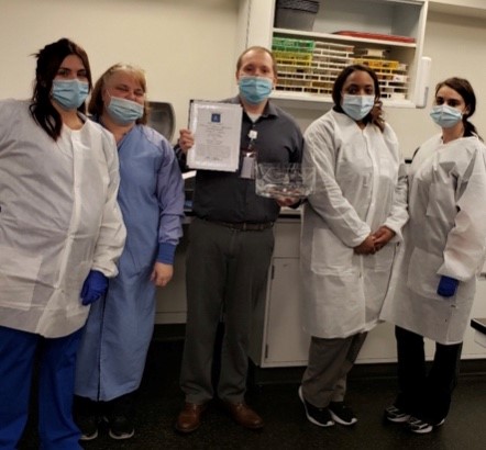 medical staff masked and holding award
