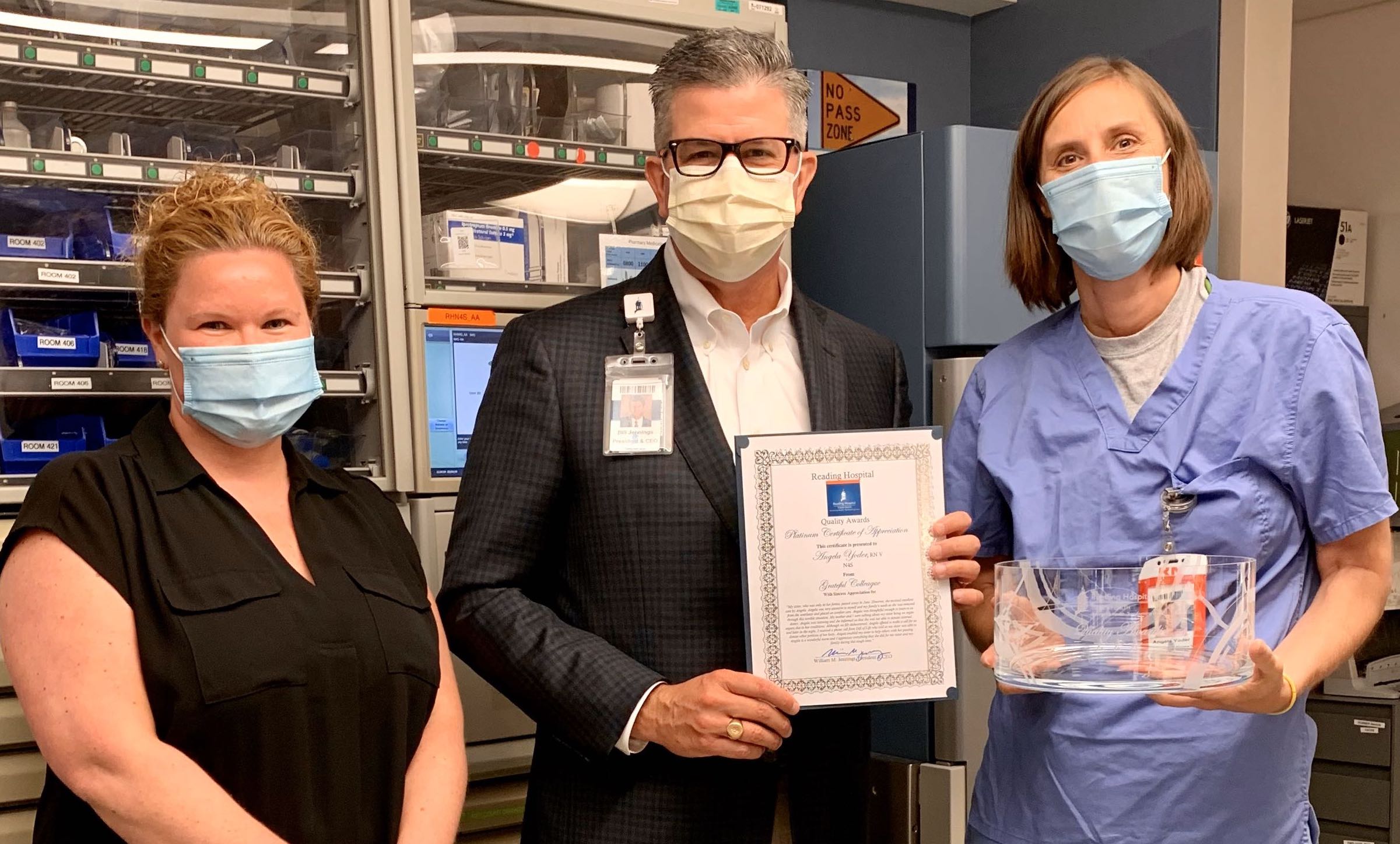 three masked people holding quality award
