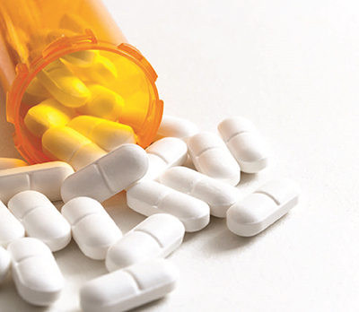 Pill bottle with white pills spilling out