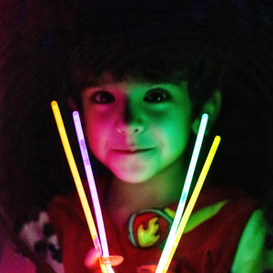 Young boy safely playing with glowsticks instead of fireworks