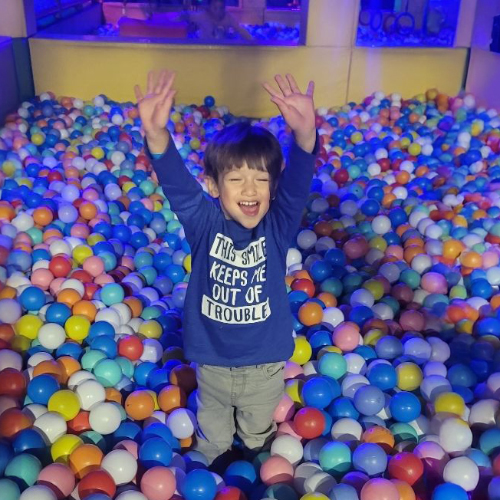 Julian celebrating in a colorful ball pit after successful heart surgery at St. Christopher's Hospital for Children