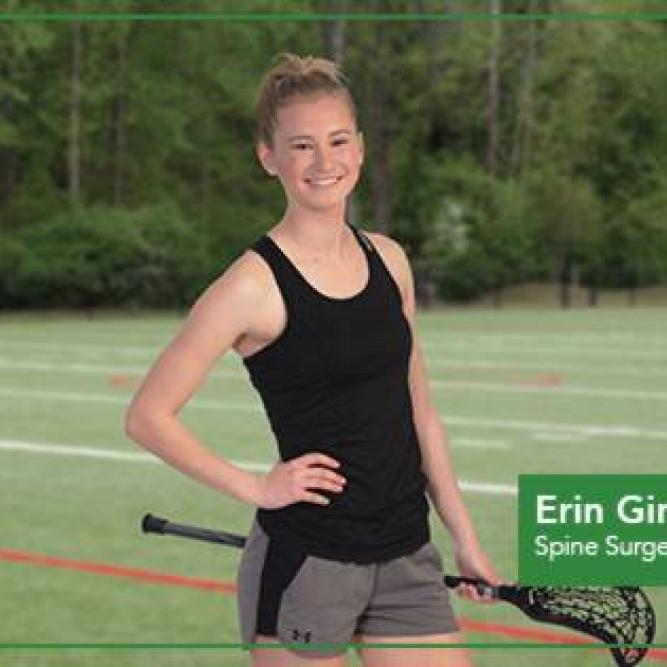 Girl with hand on her hip holding a lacrosse racket.