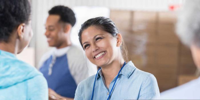 woman smiling with diverse mix of people surrounding her