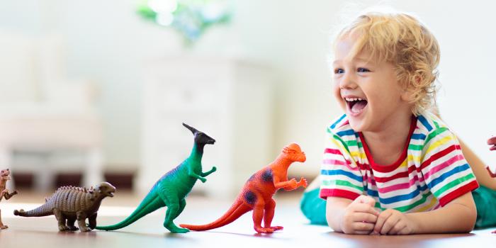 Child laughing with dinosaurs