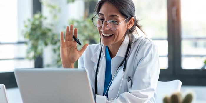 doctor smiling in front of lap top