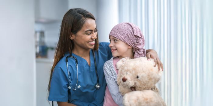 Young cancer patient smiling with medical provider 